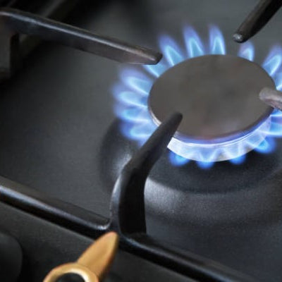1.instalación de gas; llave de estufa prendida, con una flama de color azul. 