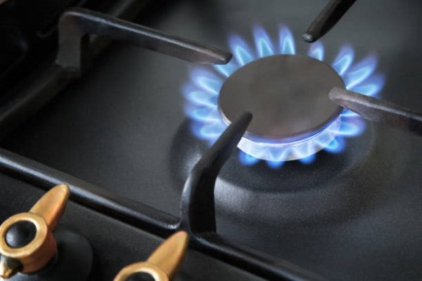 1.instalación de gas; llave de estufa prendida, con una flama de color azul. 