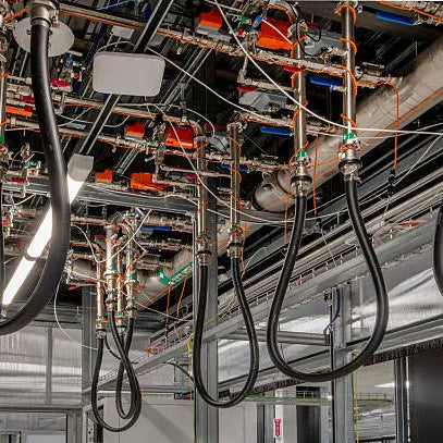 Instalación profesional de mangueras sujetas al techo con múltiples conexiones metálicas, destacando las aplicaciones de las mangueras y conexiones en sistemas industriales. 