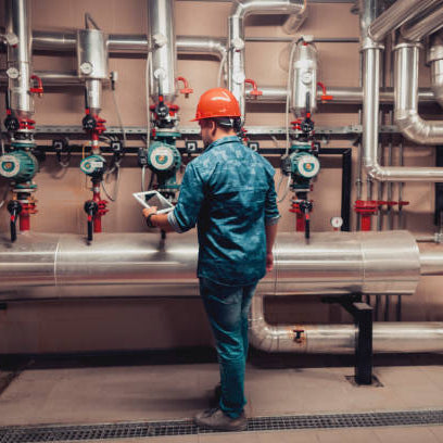 Mantenimiento industrial preventivo. persona con un traje de seguridad y casco, revisando una instalación industrial. 