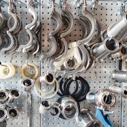 Abrazaderas metálicas colgadas en una vitrina, un elemento esencial dentro de los 10 productos de ferretería especializada más usados en mantenimiento y construcción. 